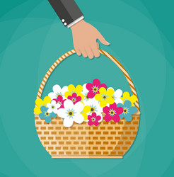 Hand carrying basket with flowers vector