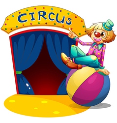 A clown sitting at the top of a ball pointing the vector image