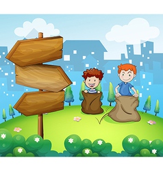 Two boys playing sack race near the arrow boards vector image