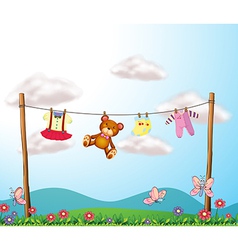 A childs clothes hanging with a teddy bear vector image