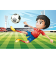 A boy playing soccer at the soccer field vector image